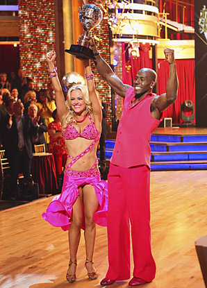 Dancing winner holds up trophy after Latin dance